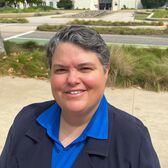 Director of Recreation and Arts Jenny Rogers Wearing a Blue Shirt and Black Blazer Standing in front of Santa Monica City Hall